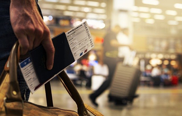 gros plan sur un billet d'avion et un passeport dans la main d'une personne